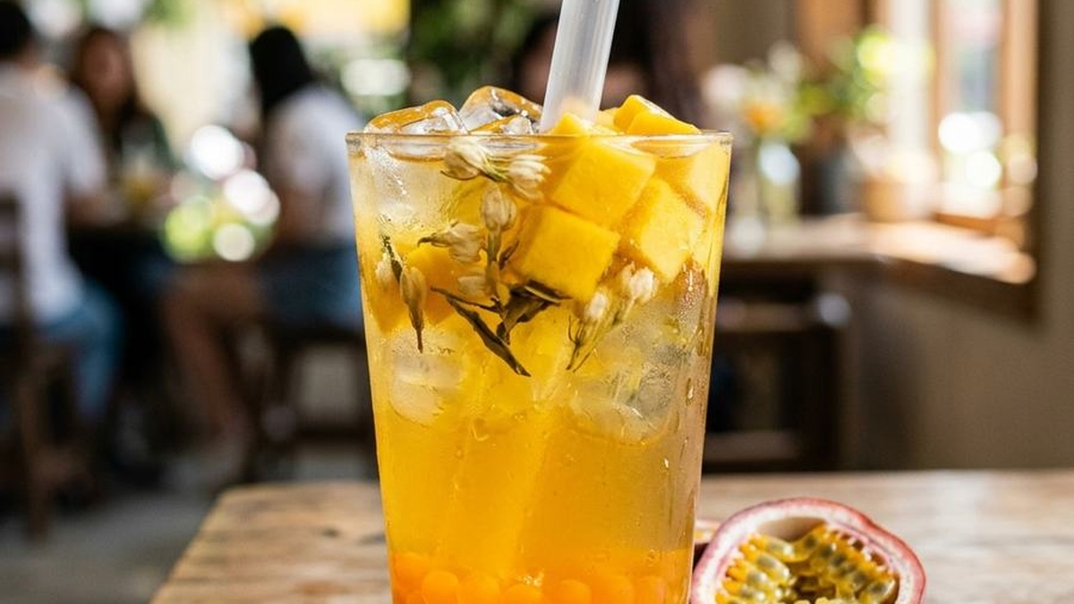 Homemade mango popping boba in a glass of fruit tea