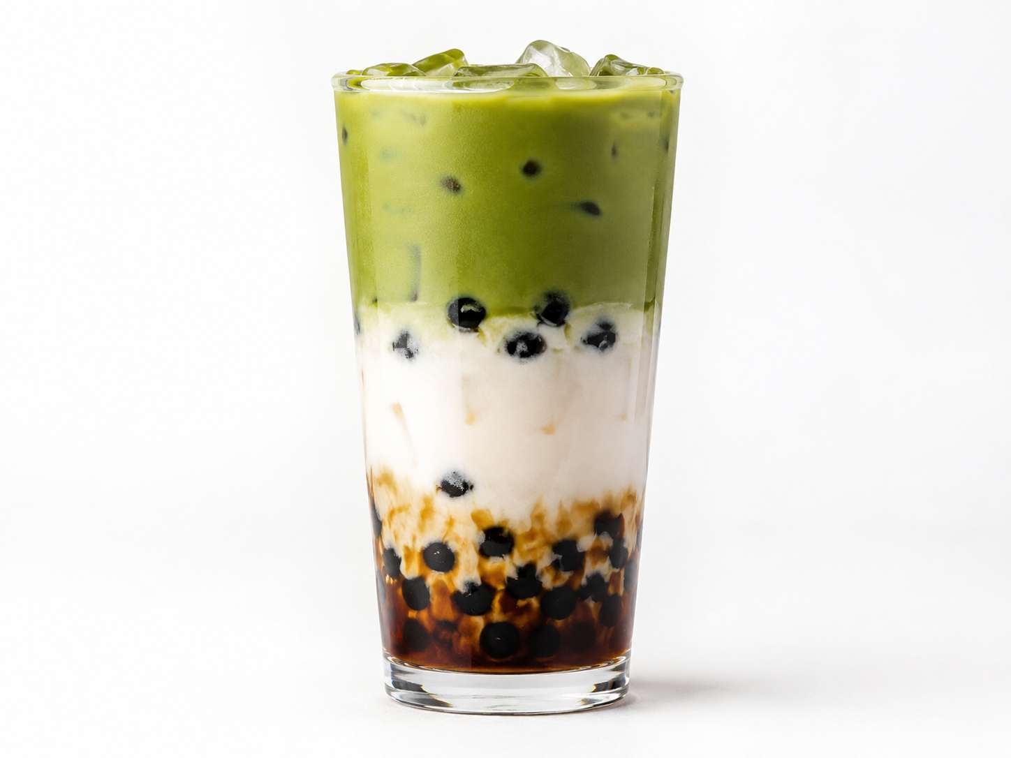Cross-section of a layered bubble tea showing brown sugar milk and matcha layers