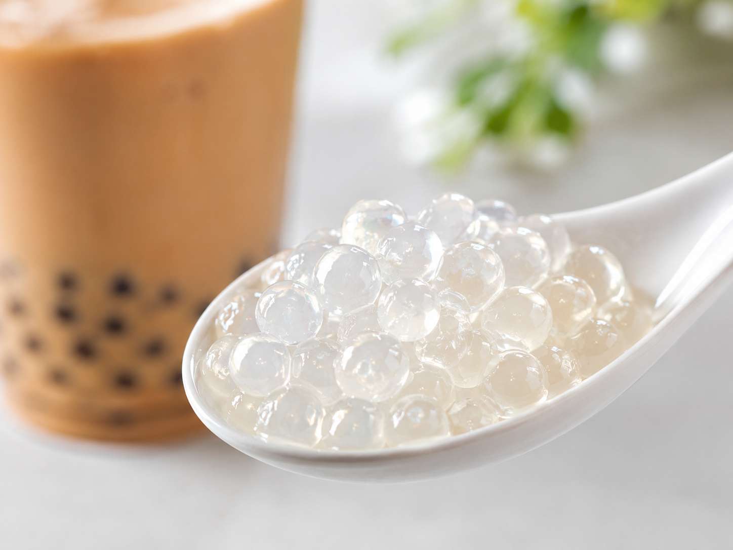 Close-up of translucent crystal boba pearls on a white ceramic spoon