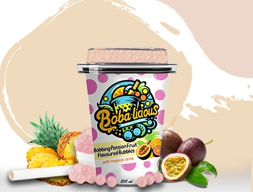 Cup of passion fruit-flavoured bubble tea with tropical bubbles, surrounded by passion fruit and pineapple.