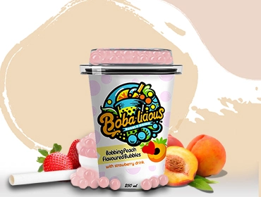 Cup of peach-flavoured bubble tea with strawberry bubbles, featuring fresh peach and strawberry ingredients.